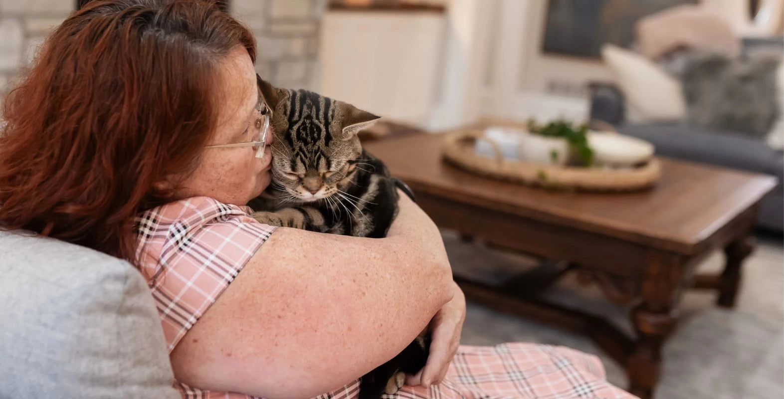 Cat owner kissing her cat beside a LoftyLoo elevated cat litter box