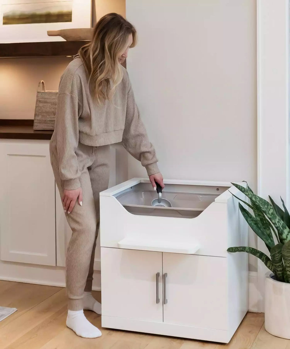 Woman standing to scoop easy to clean cat litter box 