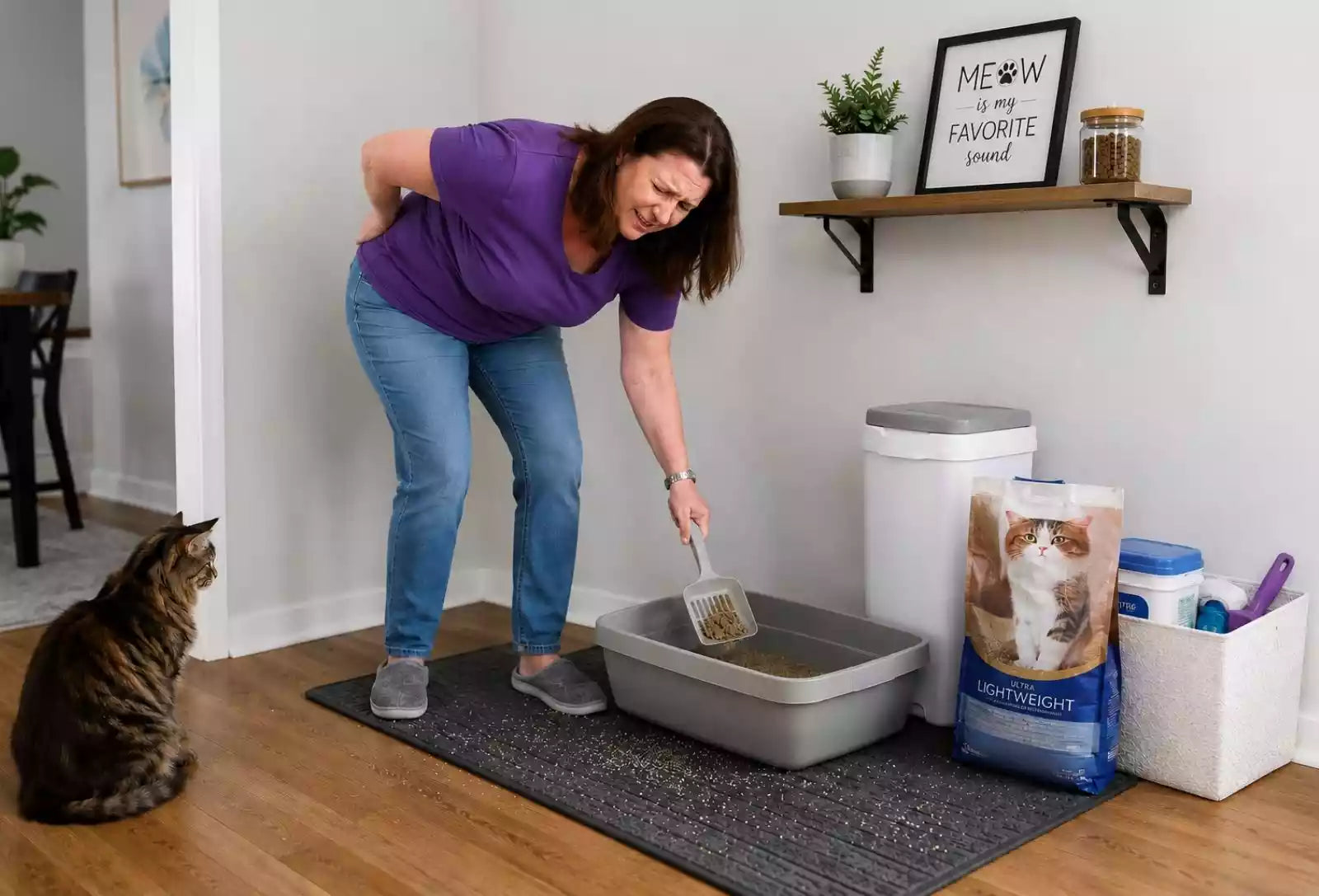 woman bending over in pain cleaning floor level cat litter box